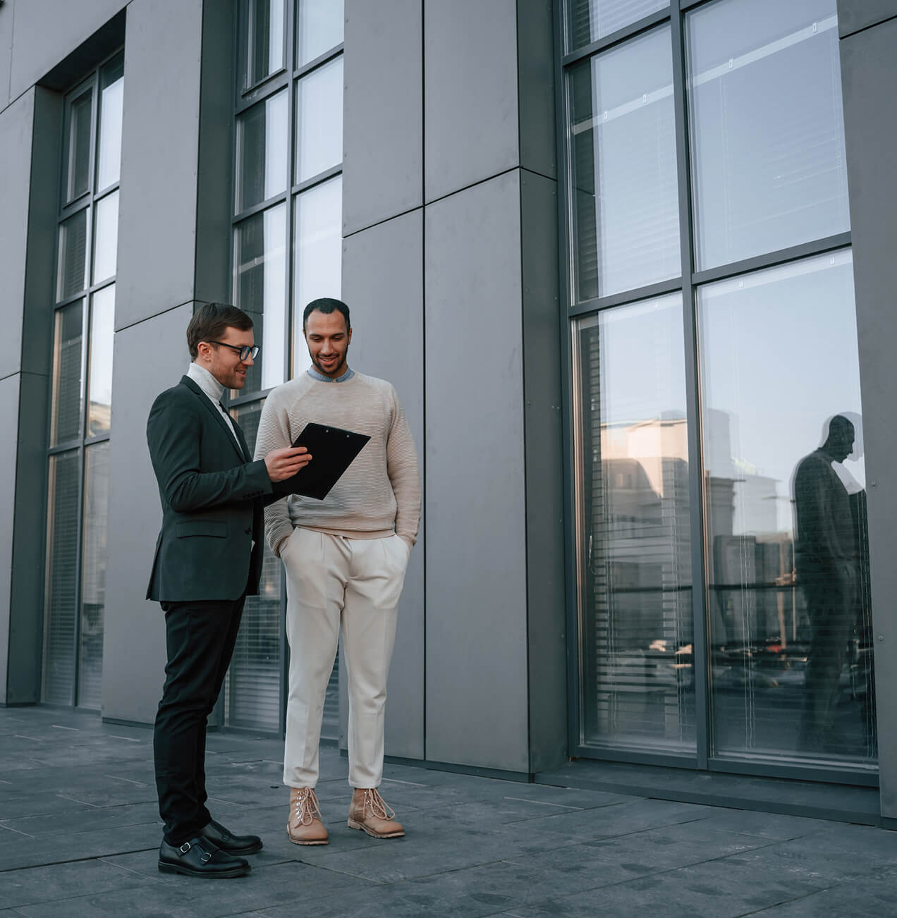 Geschäftsbesprechung vor Glasfassade – BOS Projektmanagement GmbH