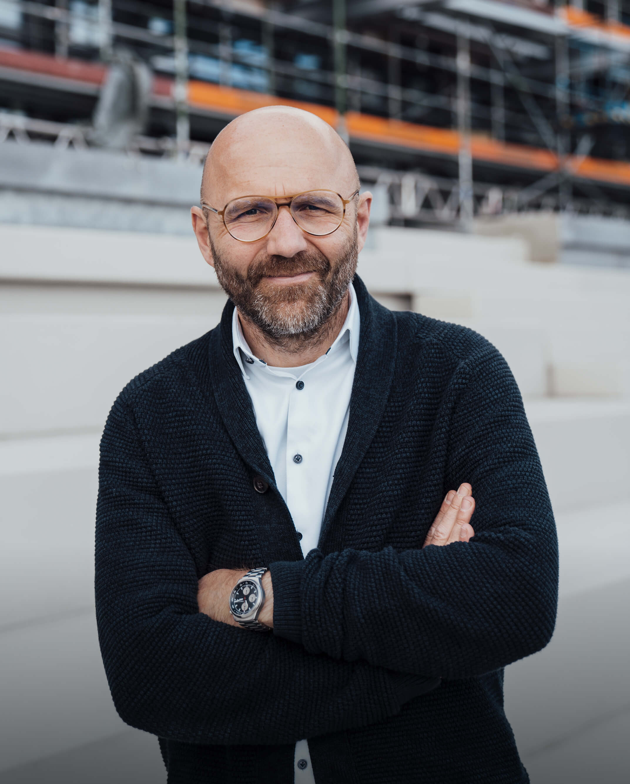 Mann mit Brille und Bart lächelt in die Kamera – Mitarbeiterportrait BOS Projektmanagement